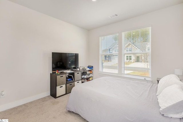 bedroom with light colored carpet, visible vents, and baseboards