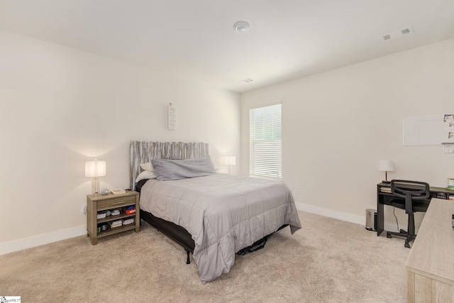 bedroom featuring baseboards, visible vents, and light colored carpet