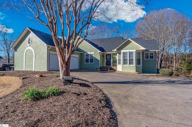 single story home featuring a garage, driveway, and stucco siding