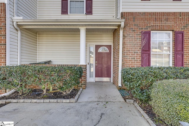 view of exterior entry with brick siding