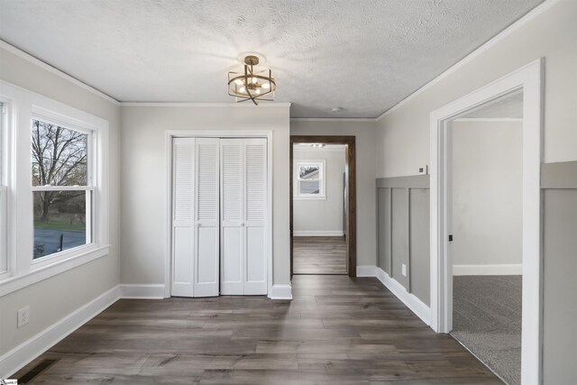 interior space with a textured ceiling, a closet, dark wood-style floors, and baseboards