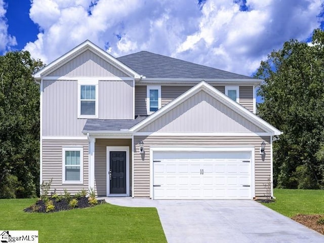 view of front of property featuring driveway, a garage, and a front yard