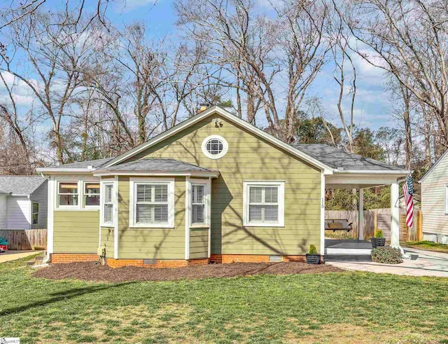 bungalow-style house featuring an attached carport, crawl space, driveway, and a front yard