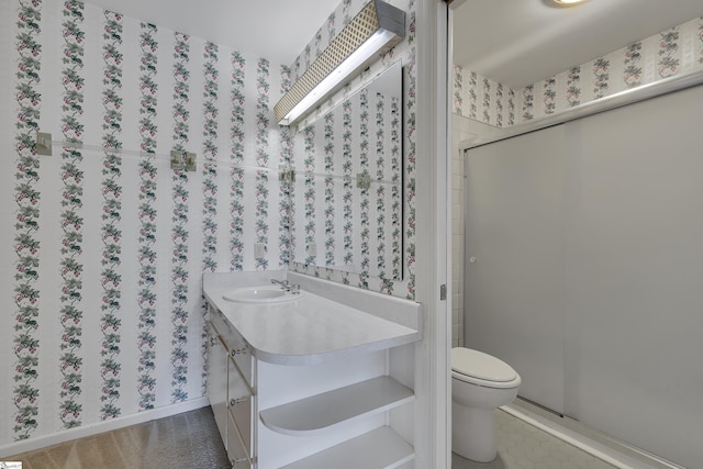 bathroom with a sink, toilet, and wallpapered walls