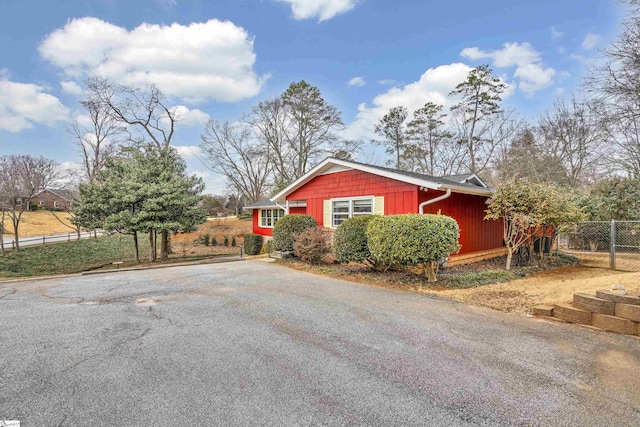 view of side of home with driveway and fence