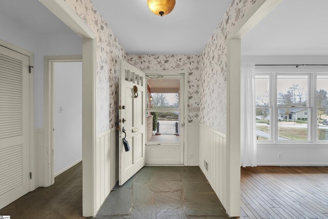 interior space featuring wainscoting, visible vents, and wallpapered walls