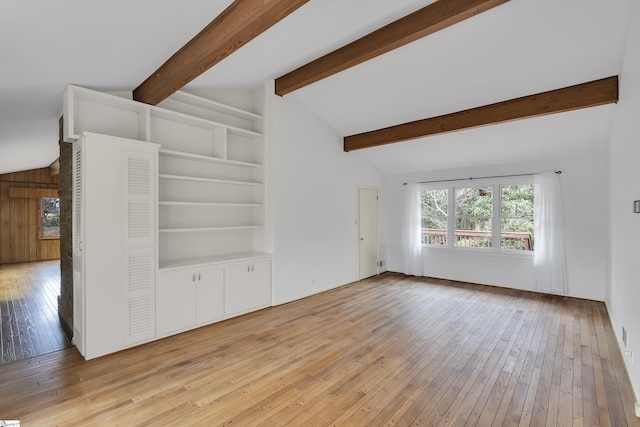 unfurnished living room with light wood-style floors, lofted ceiling with beams, and built in shelves