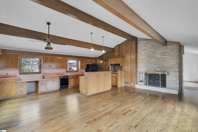 kitchen featuring vaulted ceiling with beams, hanging light fixtures, light countertops, black appliances, and a sink