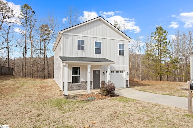 view of front of property with driveway, a garage, stone siding, covered porch, and a front lawn