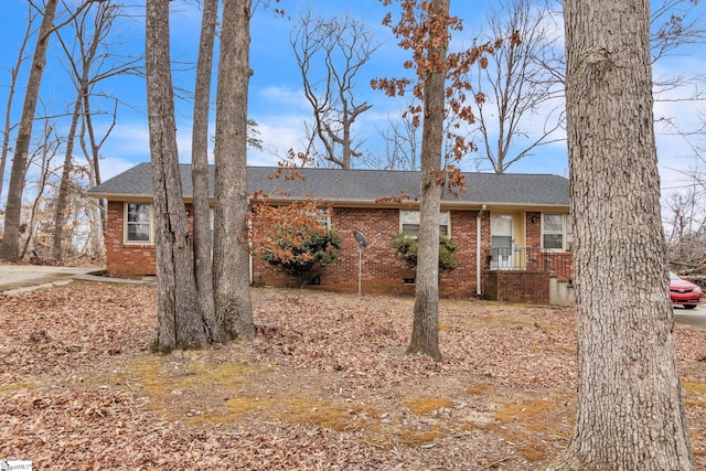 ranch-style home featuring crawl space, brick siding, and roof with shingles