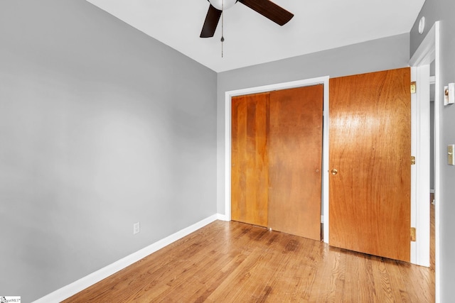 unfurnished bedroom featuring a ceiling fan, light wood-type flooring, and baseboards