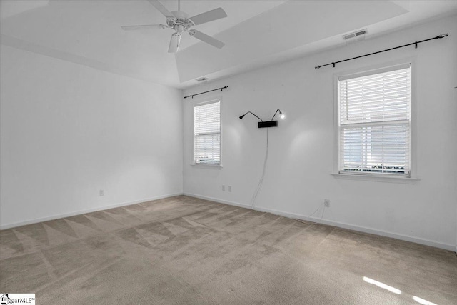 unfurnished room featuring light colored carpet, visible vents, ceiling fan, and baseboards