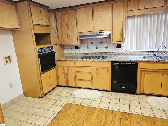 kitchen featuring light tile patterned floors, tasteful backsplash, a sink, under cabinet range hood, and black appliances