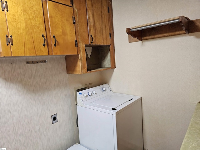 clothes washing area with washer / clothes dryer and cabinet space