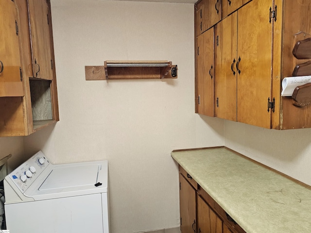 clothes washing area with washer / dryer and cabinet space