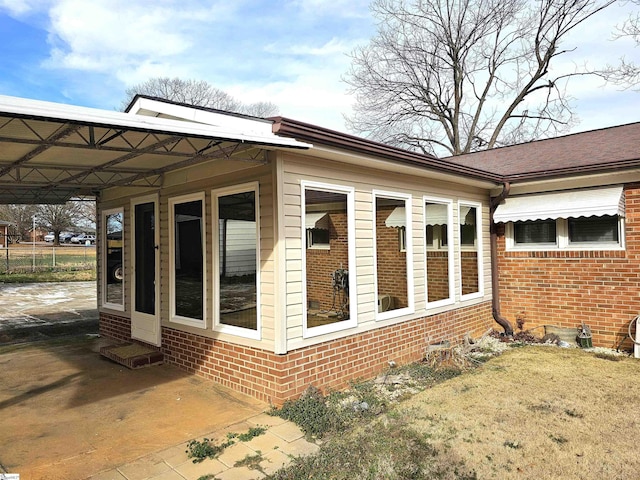 view of property exterior with a carport and brick siding