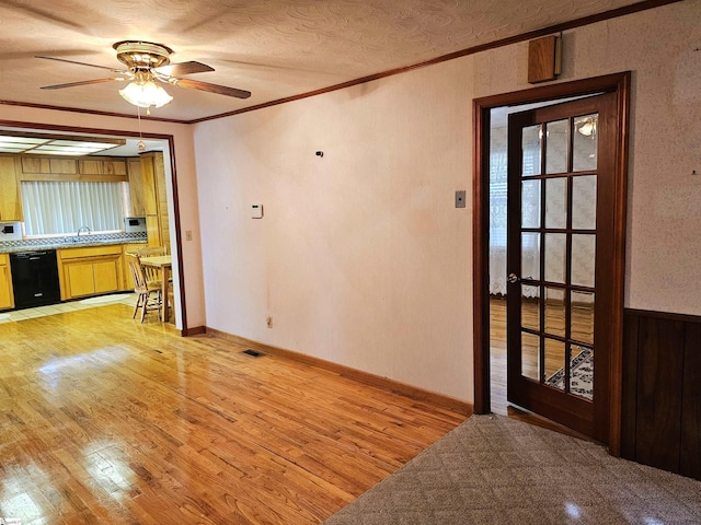 interior space featuring visible vents, ornamental molding, ceiling fan, a textured ceiling, and light wood-type flooring