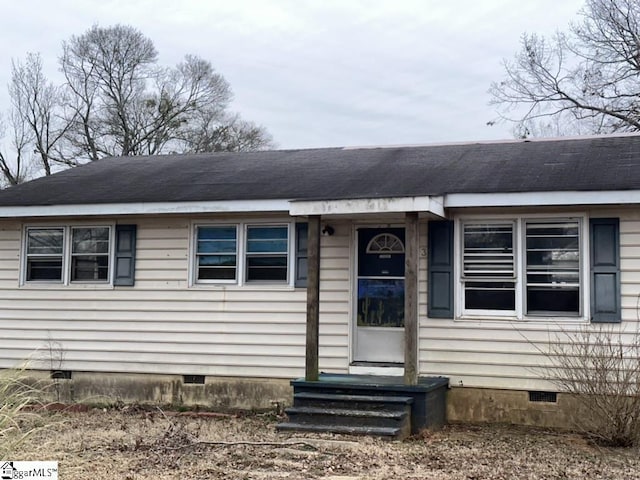 view of front of house with entry steps, a shingled roof, and crawl space