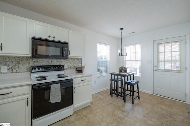 kitchen with white cabinets, black microwave, light countertops, and electric stove