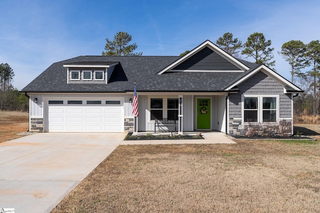 view of front of home featuring stone siding, a shingled roof, concrete driveway, and a front yard