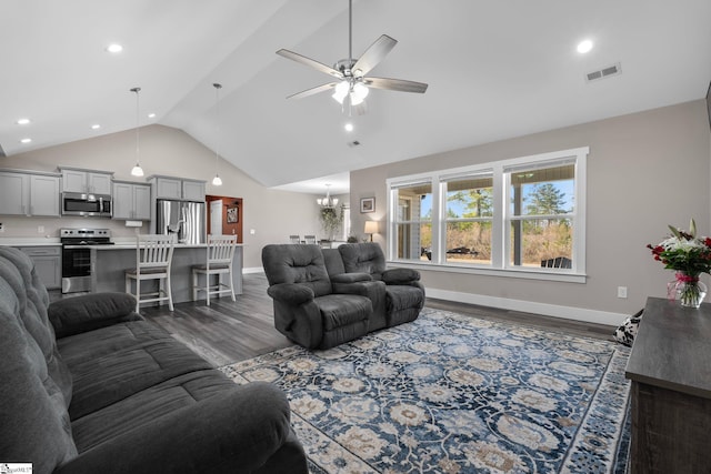 living area featuring ceiling fan with notable chandelier, dark wood-style flooring, visible vents, and baseboards