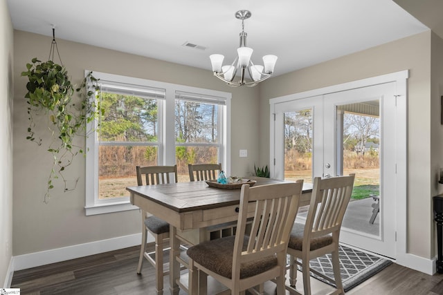 dining space with baseboards, a notable chandelier, visible vents, and dark wood-type flooring