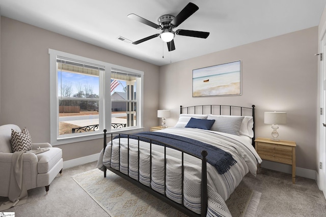 bedroom featuring a ceiling fan, light colored carpet, visible vents, and baseboards