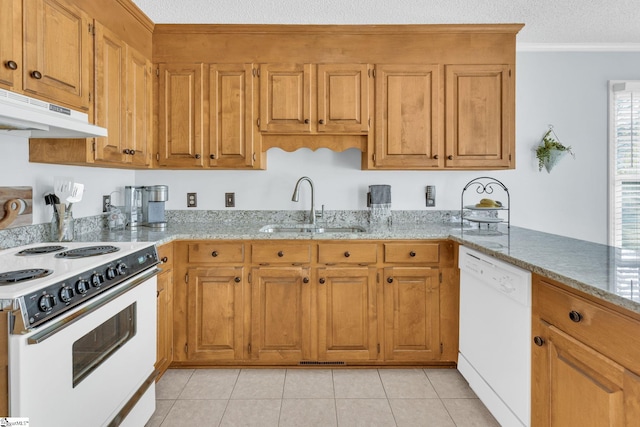 kitchen with white appliances, a sink, under cabinet range hood, and light stone countertops