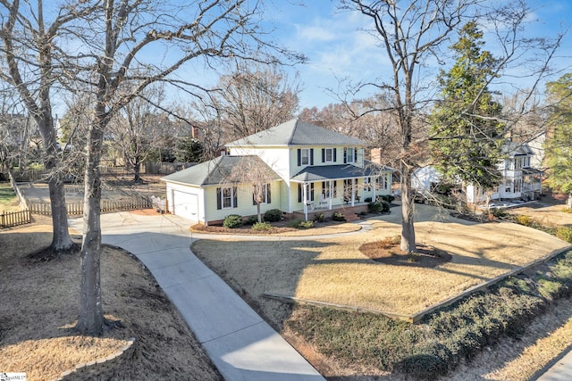 view of front of house featuring a garage, fence, a porch, and concrete driveway