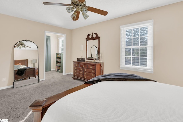 bedroom with light colored carpet, ceiling fan, and baseboards