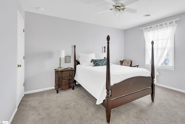 bedroom featuring baseboards, visible vents, light carpet, and a textured ceiling