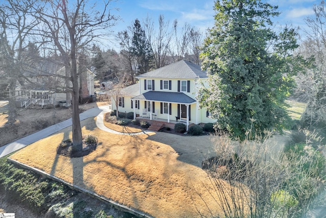 view of front of house featuring covered porch, roof with shingles, and driveway