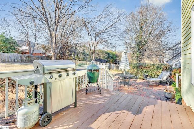 deck with a fenced backyard, a grill, and outdoor dining space