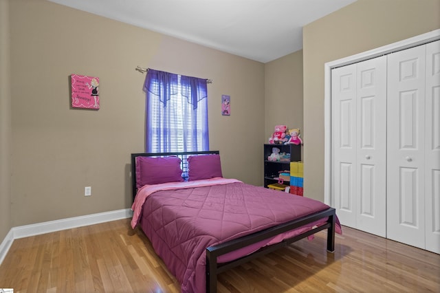 bedroom featuring a closet, wood finished floors, and baseboards