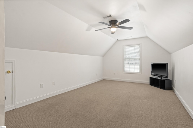 additional living space with lofted ceiling, ceiling fan, light carpet, visible vents, and baseboards