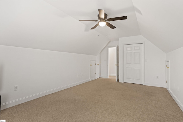 additional living space with lofted ceiling, ceiling fan, baseboards, and light colored carpet