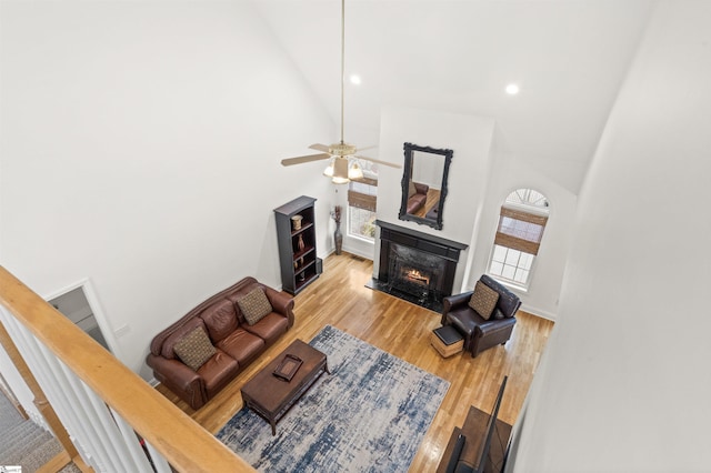 living room with recessed lighting, light wood-style flooring, a premium fireplace, a ceiling fan, and high vaulted ceiling