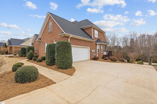 view of side of home featuring driveway, brick siding, and roof with shingles