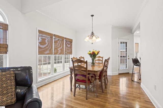 dining space with a notable chandelier, crown molding, wood finished floors, and baseboards