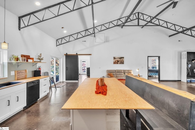 kitchen with high vaulted ceiling, a barn door, open floor plan, concrete flooring, and dishwasher