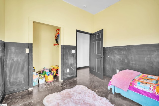 bedroom with finished concrete floors, a closet, and a spacious closet