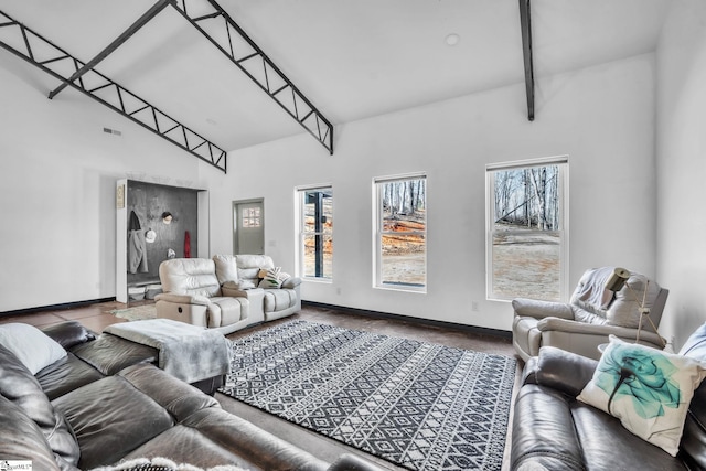 living area featuring a towering ceiling and baseboards