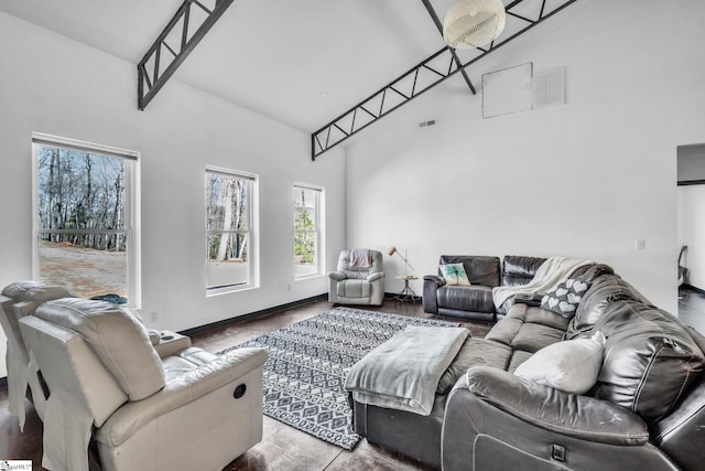 living room featuring visible vents, a towering ceiling, and baseboards