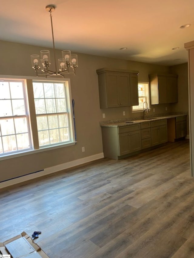 kitchen with light countertops, wood finished floors, decorative light fixtures, and a notable chandelier