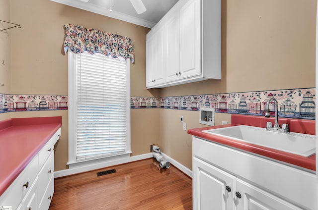 laundry area featuring hookup for a washing machine, a sink, visible vents, cabinet space, and electric dryer hookup