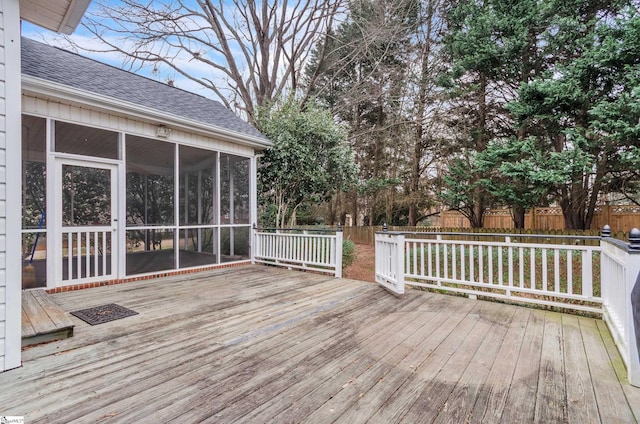 wooden terrace featuring a sunroom and fence