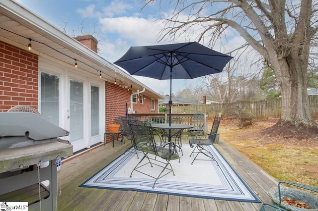 wooden deck with outdoor dining space and fence