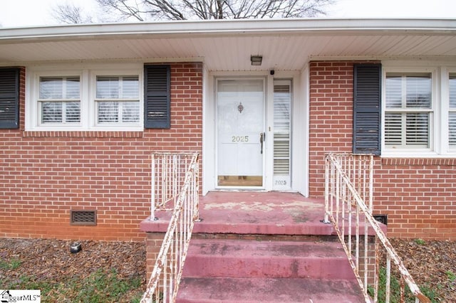 property entrance with crawl space and brick siding