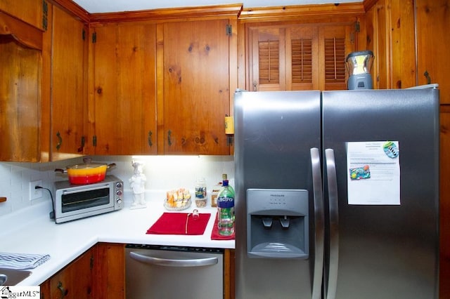 kitchen featuring a toaster, brown cabinets, stainless steel appliances, light countertops, and backsplash