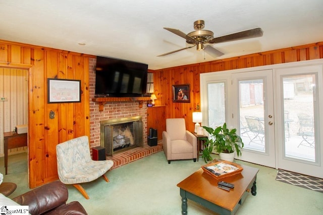 living area with wood walls, a fireplace, carpet flooring, and a wealth of natural light